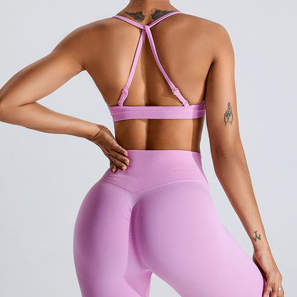 Barbie Pink seamless strappy yoga bra by Alabaster, featuring breathable fabric and a stylish design.