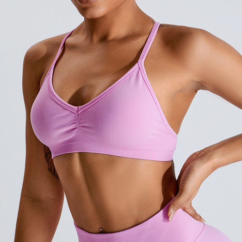Barbie Pink seamless strappy yoga bra by Alabaster, featuring breathable material and a stylish design.