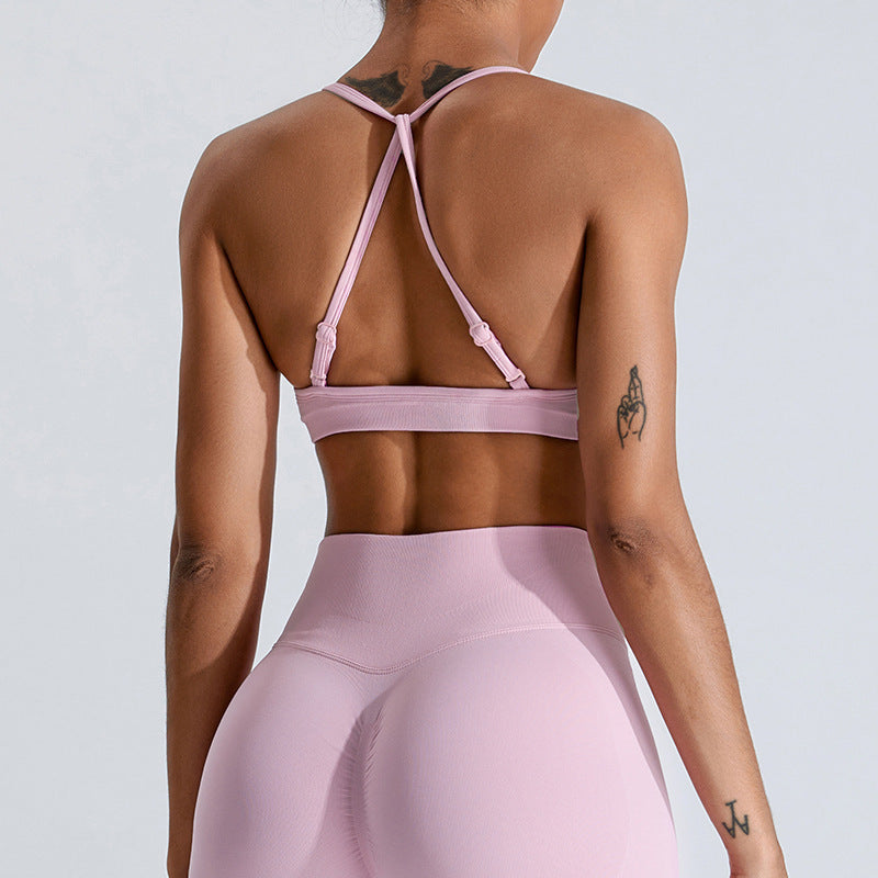 Barbie pink seamless strappy yoga bra by Alabaster, designed for breathability and comfort in activewear.
