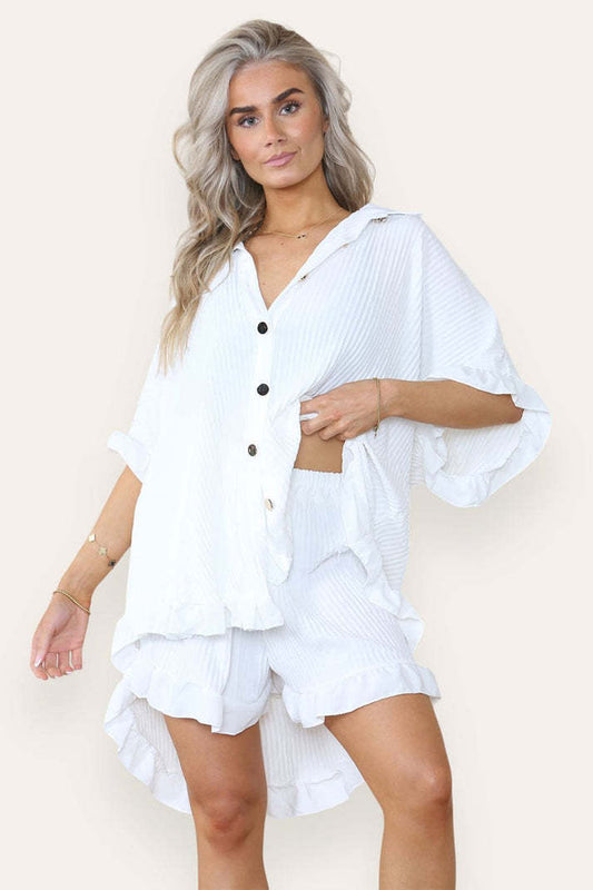 Turquoise women's ruffle co-ord set featuring an oversized button shirt and shorts with gold buttons by Alabaster