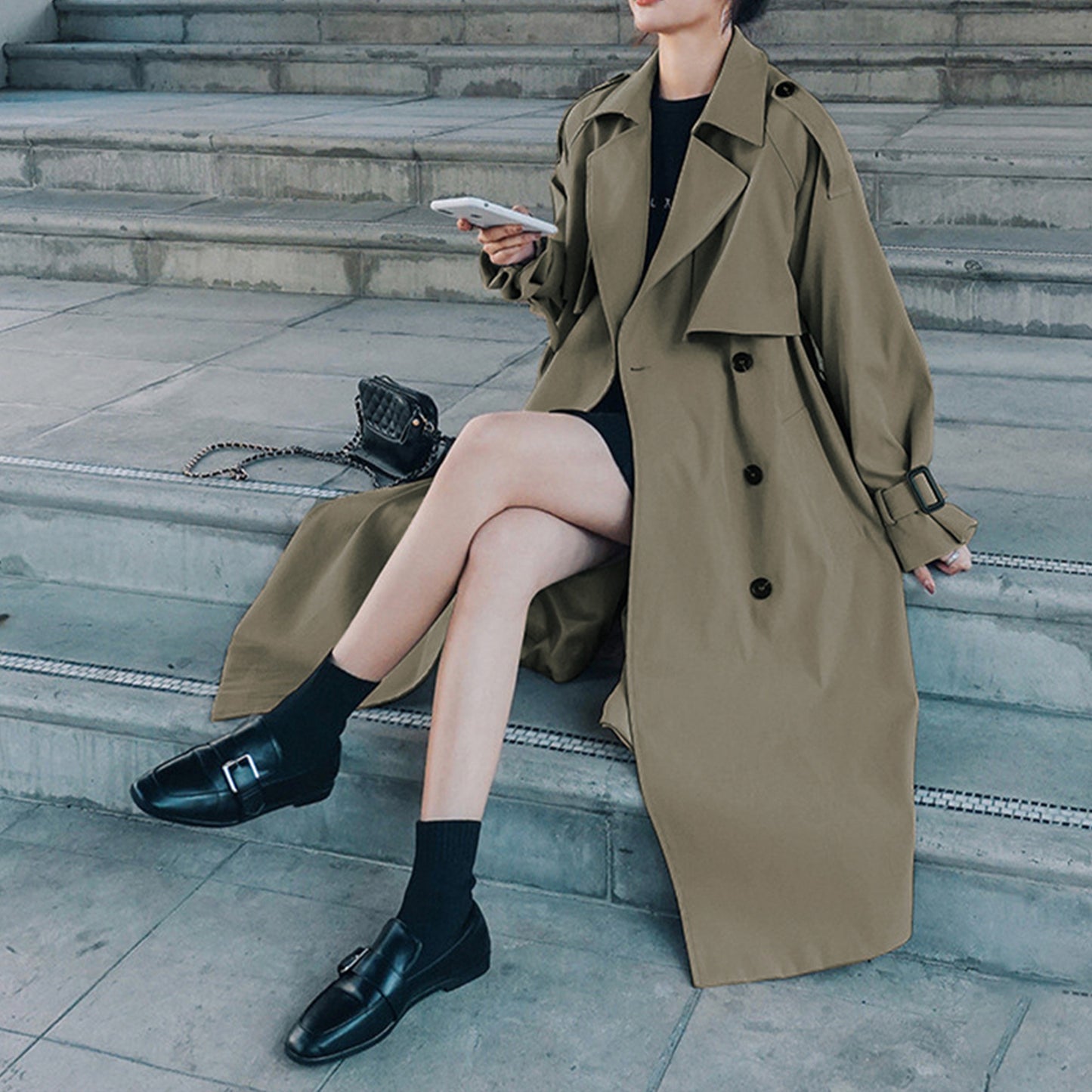 Gray green oversized mid-length trench coat by Alabaster with adjustable cuffs and double-breasted design.