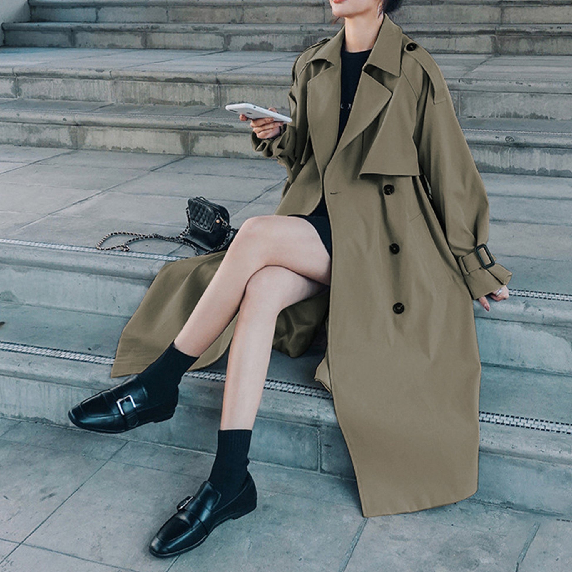 Gray green oversized mid-length trench coat by Alabaster with adjustable cuffs and double-breasted design.