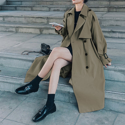 Gray green oversized mid-length trench coat by Alabaster with adjustable cuffs and double-breasted design.