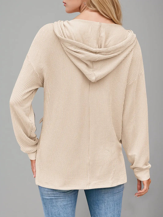 Tan oversized drawstring hoodie with dropped shoulders and long sleeves, featuring a textured fabric.